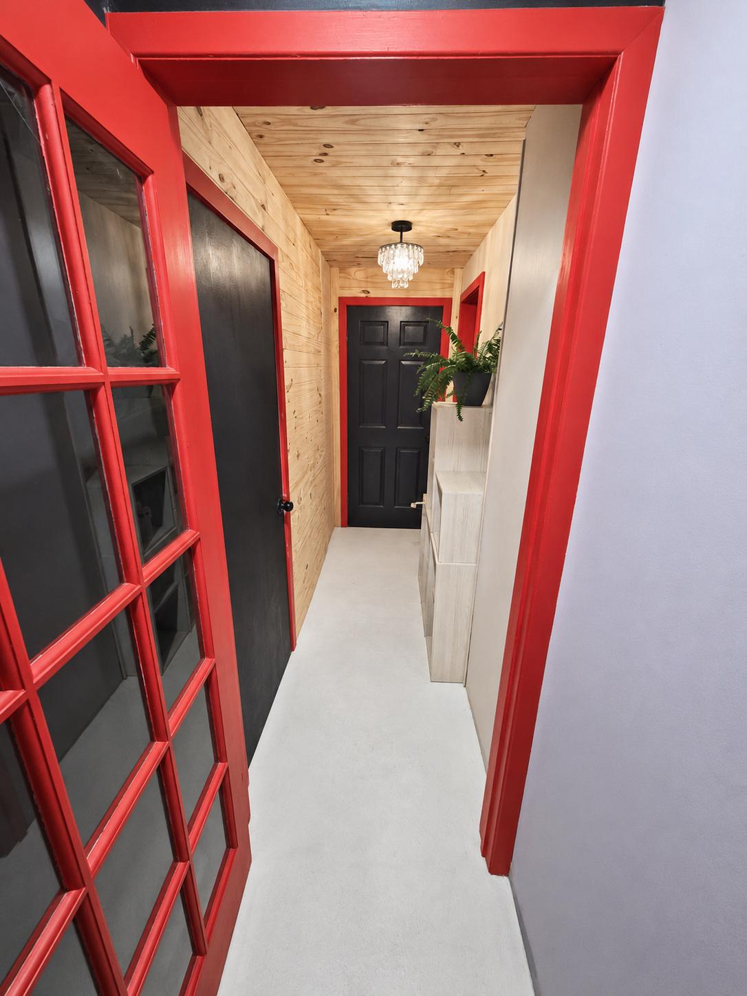 La porte rouge du gîte, ouverte vers le bachelor